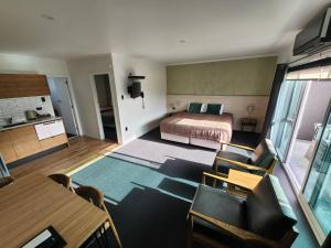 um quarto com uma cama, uma mesa e cadeiras em The Strand em New Plymouth