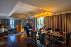 a dining room with a table and chairs at ARTOTEL TS Suites Surabaya in Wonokromo