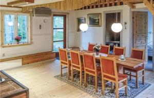 ein Esszimmer mit einem Holztisch und Stühlen in der Unterkunft Beautiful Home In Eringsboda With 5 Bedrooms And Wifi in Pålsmåla