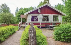 una pequeña casa roja y blanca con una estatua delante de ella en Amazing Home In Eringsboda With Wifi, en Pålsmåla 22 fotos más