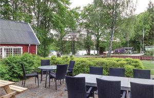 una mesa y sillas en un patio con un granero rojo en Stunning Home In Eringsboda With Kitchen, en Pålsmåla