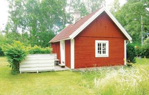 mały czerwony dom na polu trawy w obiekcie Amazing Home In Lttorp With Kitchen w mieście Gamleby