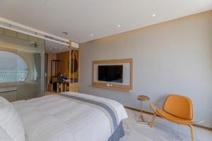 魚池郷にあるサンムーンレイク アポロリゾートホテルのベッドルーム(ベッド1台、椅子、テレビ付)