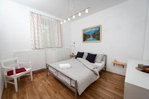 a white living room with a couch and a table at Apartment Island Country House in Savinja Valley in Žalec