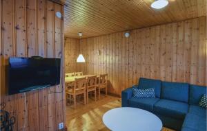 a living room with a couch and a table and a television at Stunning Home In Sysslebck With Wifi in Branäs