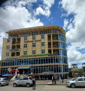 un bâtiment avec des voitures garées devant lui dans l'établissement bruhway hotel, à Addis-Abeba