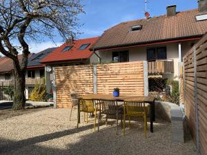 une table et des chaises en bois devant une maison dans l'établissement Ferienwohnungen Bohner/Wohnung Elisabeth, à Meersburg