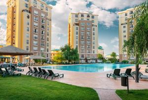 a swimming pool with lounge chairs and buildings at Summer cosmopolis in Creţuleasca