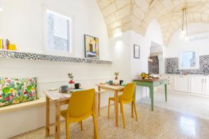 a kitchen with two tables and yellow chairs in a room at Civico 22 B&B in Cannole
