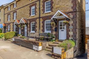 a brick house with a bench in front of it at 3 Canalside Cottages in Towcester