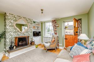 a living room with a fireplace and a mirror at 3 Canalside Cottages in Towcester