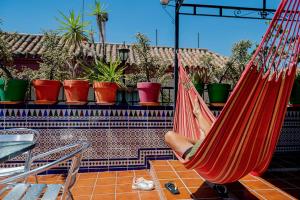 a person sitting in a hammock on a patio at Hostel Triana Backpackers in Seville