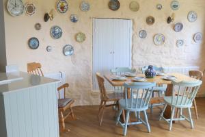 a dining room with a table and plates on the wall at Penllain in Newport Pembrokeshire
