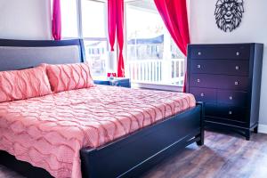 ein Schlafzimmer mit einem Bett, einer Kommode und einem Fenster in der Unterkunft Private 3Br Gameroom Home In Houston - Sleeps 15 - 2705A in Houston