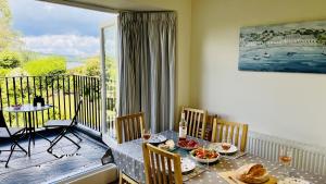 une salle à manger avec une table et un balcon dans l'établissement Riverview - Family river retreat a short walk from the quay, à Dittisham