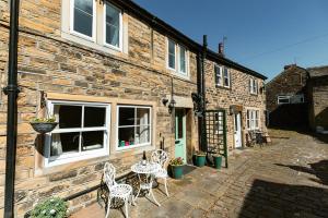 a brick building with tables and chairs in front of it at FRANCE FOLD COTTAGE - Cosy 1 Bed Cottage Close to Holmfirth & the Peak District, Yorkshire in Honley