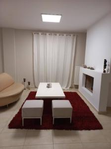 sala de estar con mesa, 2 sillas y chimenea en Grand Afroditi LUX en Pýrgos