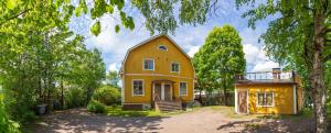 une maison jaune assise au milieu d'une cour dans l'établissement Palazzo Patriarcale in Turku, à Turku