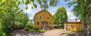 a yellow house sitting in the middle of a yard at Palazzo Patriarcale in Turku in Turku