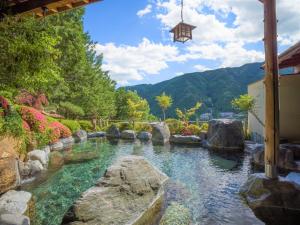 a pool of water with rocks in a garden at Yunoshimakan in Gero