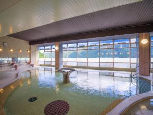a large swimming pool in a building with a large window at Yunoshimakan in Gero
