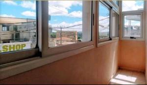 an empty room with three windows in a building at OCEANIS HOME & VOYAGES in Ivato