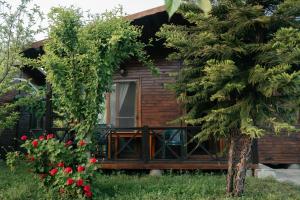 a log cabin with a balcony and flowers at Serenity Bungalows in Cıralı