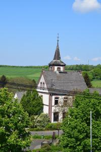 un vieux bâtiment en briques avec une tour en haut dans l'établissement TKS-HOME, à Mündersbach