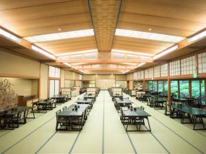 a large dining room with tables and chairs at Yunoshimakan in Gero