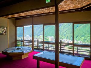a room with two beds and a large window at Yunoshimakan in Gero