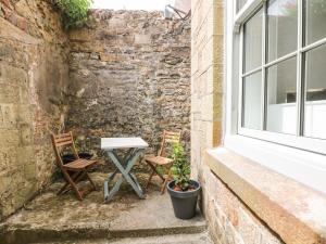 una mesa y dos sillas sentadas junto a una ventana en 1 Regents Mews, en Penzance