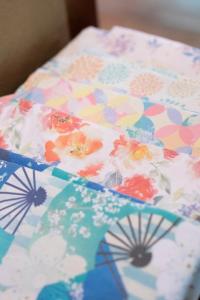 a close up of a flowered umbrella on a bed at Yunoshimakan in Gero