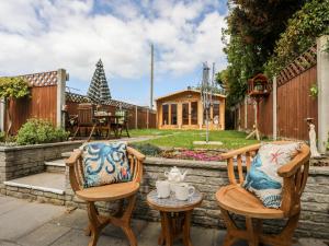 a patio with two chairs and a table at Dolwar in Amlwch