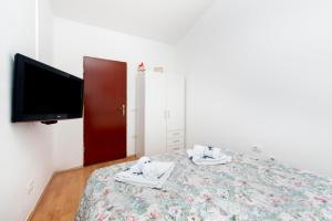 sypialnia z łóżkiem z telewizorem i butami w obiekcie Studio Nena w Rovinj +5 zdjęć