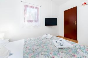 sypialnia z łóżkiem z ręcznikami i telewizorem w obiekcie Studio Nena w Rovinj