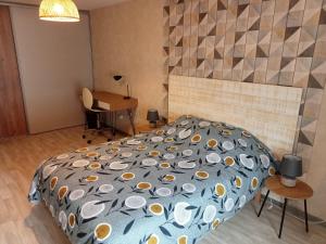 - une chambre avec un grand lit et un bureau dans l'établissement Loft Joinvillois, à Joinville
