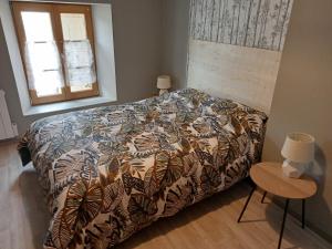 ein Schlafzimmer mit einem Bett mit einer Bettdecke und einem Fenster in der Unterkunft Loft Joinvillois in Joinville