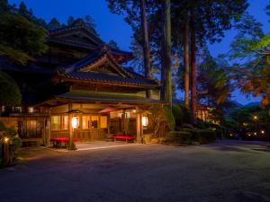 an asian building with red benches in front of it at Yunoshimakan in Gero