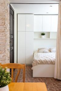 Laguna Self Check-in في نيدا: غرفة نوم بسرير مع دواليب بيضاء وطاولة