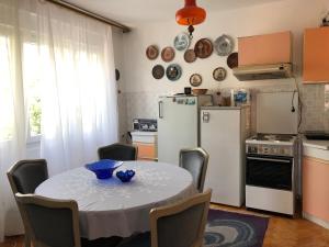 małą kuchnię ze stołem i lodówką w obiekcie Apartment TARGET w mieście Cetynia