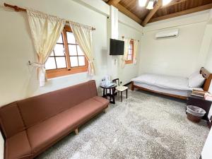 a living room with a couch and a bed at 芹壁山城民宿 Chinbe Hill Village House B&B in Beigan