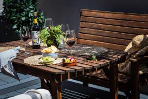 een houten tafel met glazen wijn en eten erop bij Gulls Rest - Charming Cottage in the heart of historic Dartmouth in Dartmouth