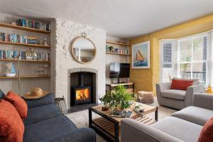 a living room with a fireplace and a couch at Gulls Rest - Charming Cottage in the heart of historic Dartmouth in Dartmouth