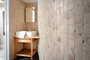 een badkamer met een wastafel en een betegelde muur bij Gulls Rest - Charming Cottage in the heart of historic Dartmouth in Dartmouth +28 foto's