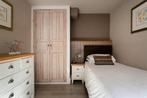 een slaapkamer met 2 bedden en een kast bij Gulls Rest - Charming Cottage in the heart of historic Dartmouth in Dartmouth