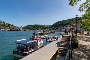 een boot is aangemeerd bij een dok naast het water bij Gulls Rest - Charming Cottage in the heart of historic Dartmouth in Dartmouth