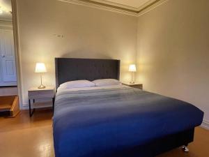 een groot bed in een slaapkamer met 2 lampen bij Marengo Holiday House in Marengo