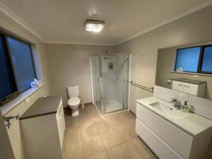 a bathroom with a shower and a toilet and a sink at Ocean Road Holiday House in Marengo +7 photos