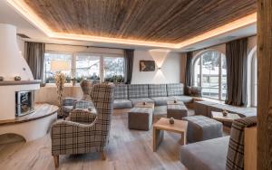 sala de estar con sofá y sillas en Alpenheim Charming & Spa Hotel, en Ortisei