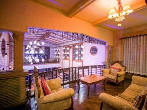 a living room with chairs and a table and a chandelier at Yunoshimakan in Gero